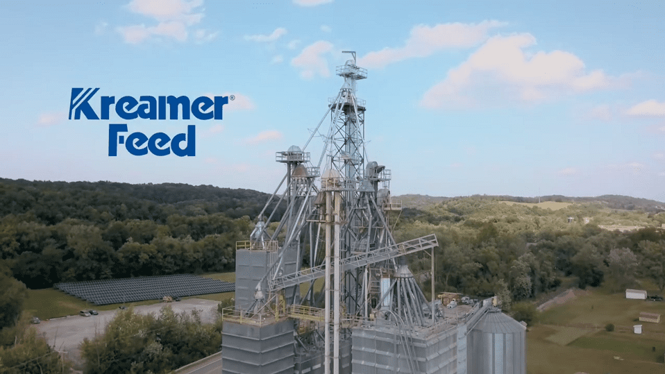 Drone view of Kreamer Feed’s mill with grain elevators, solar array, and rolling hills.
